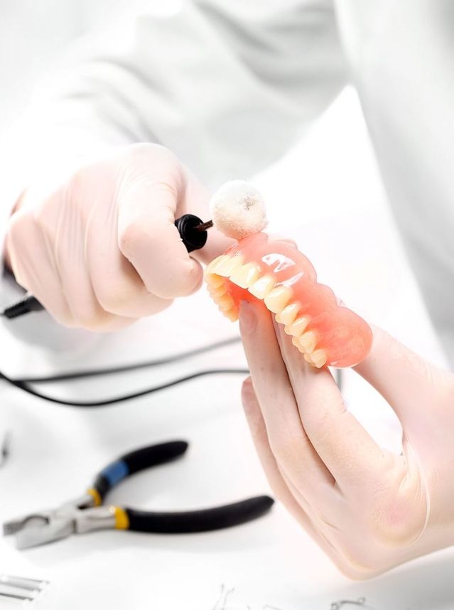 Polieren eines künstlichen Gebisses mit einem rotierenden Werkzeug im Zahnlabor